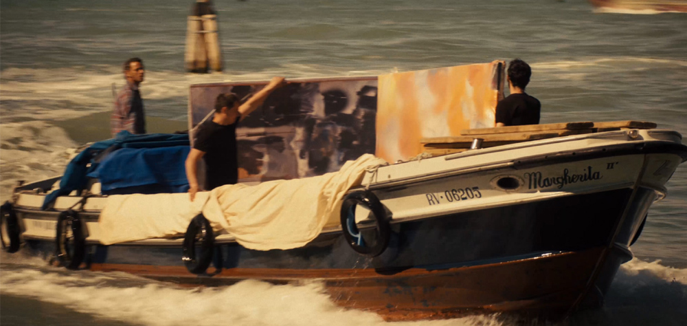 Três homens, a bordo de um barco pequeno, levam um quadro